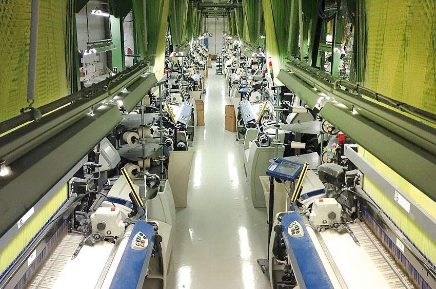 Weaving room with modern looms producing high-quality cotton fabrics