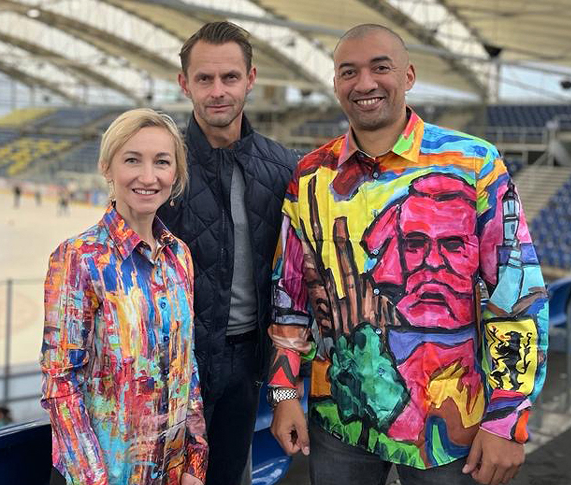 Aljona Savchenko lleva la blusa HAPPY de GERMENS y Robin Szolkowy lleva la camisa WELCOME CHEMNITZ 2025 de GERMENS