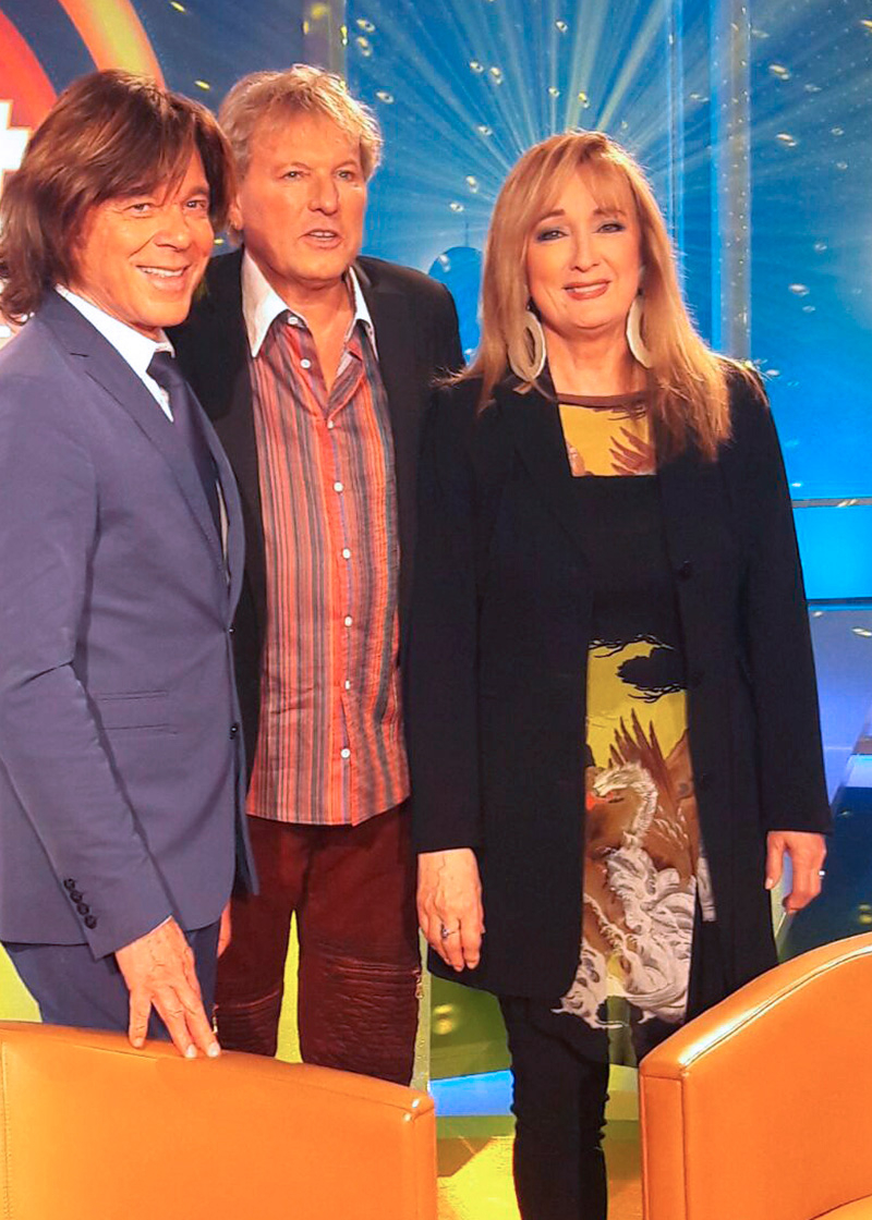 El famoso cantante de música pop Bernhard Brink se encuentra con su colega Jürgen Drews en el programa musical de la mdr «Die besten Hits aller Zeiten» y luce la camisa roja ALPHA CENTAURI RED de GERMENS artfashion