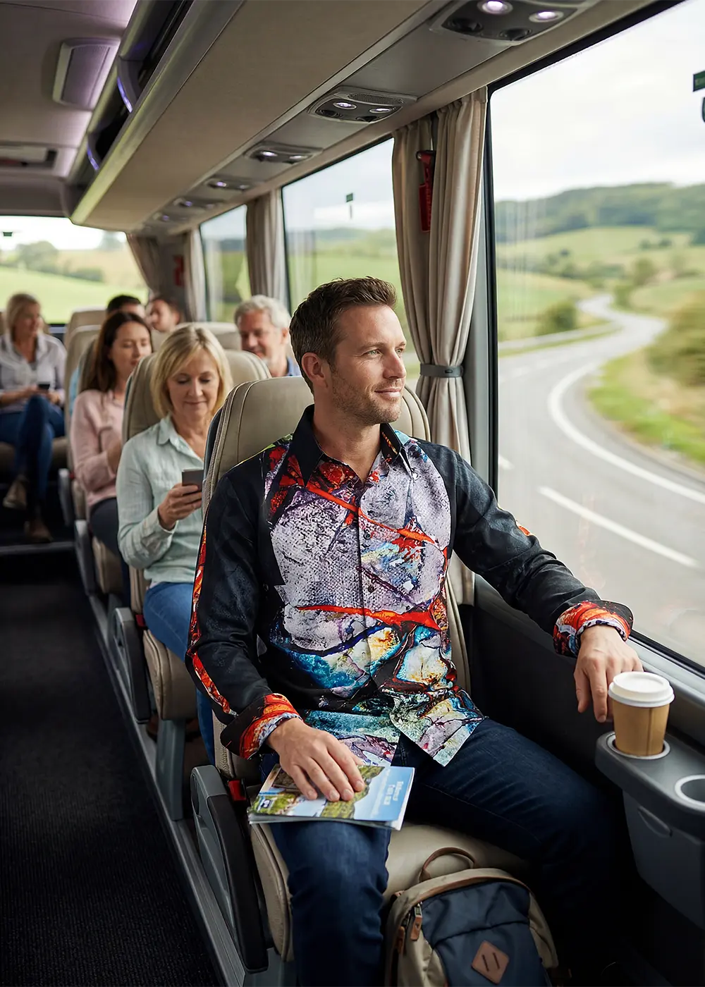 Ein Mann unternimmt eine Busreise und schaut zum Fenster hinaus. Er trägt das GERMENS Hemd BLUT, BRUDER!