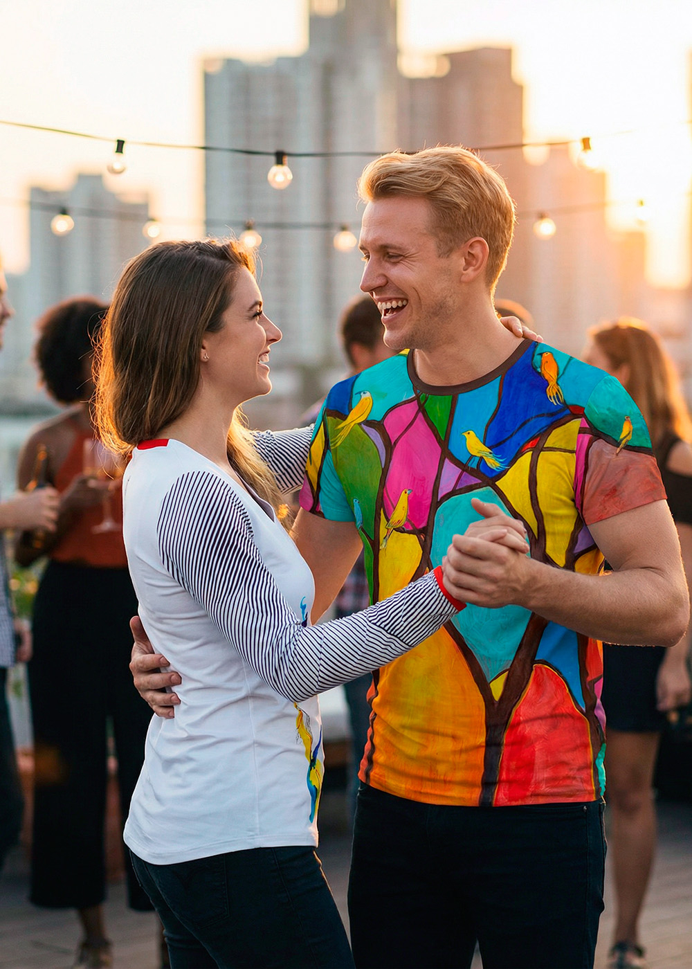 La chica lleva la camiseta de manga larga HERZBLUT de GERMENS y su pareja de baile lleva la camiseta BIRDMAN de GERMENS