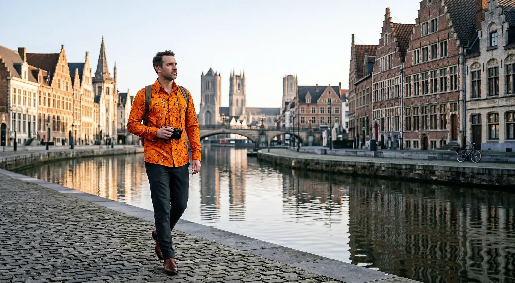 A tourist strolls through the Belgian city of Ghent. He is wearing the GERMENS GRAVUR ORANGE shirt.