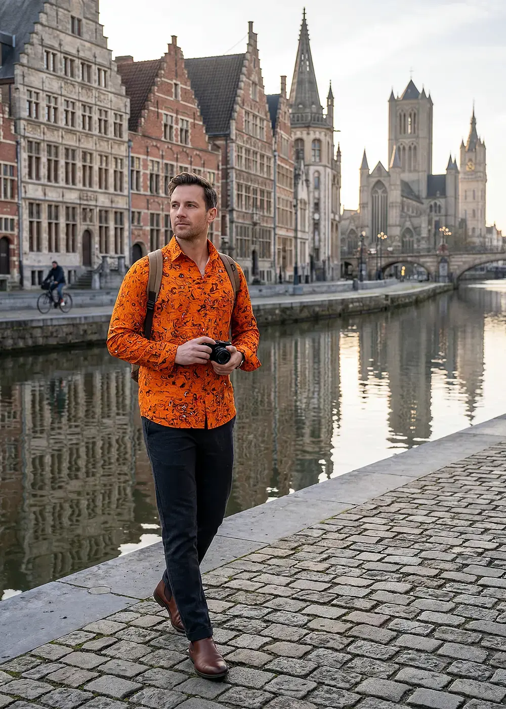 A tourist strolls through the Belgian city of Ghent. He is wearing the GERMENS GRAVUR ORANGE shirt.