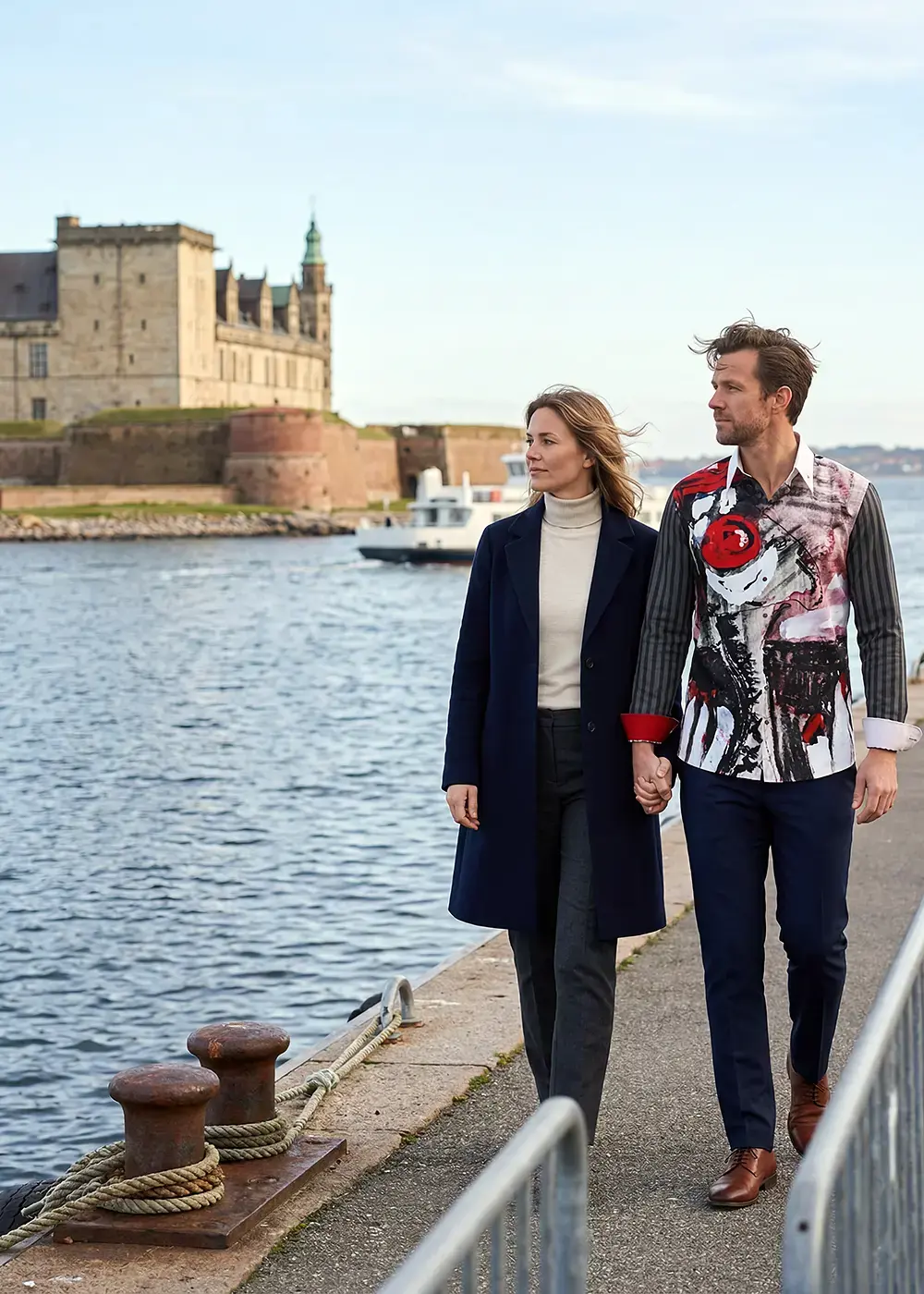 A married couple strolls through the Danish city of Helsingør. The man wears the gray and red NEZ ROUGE shirt by GERMENS.