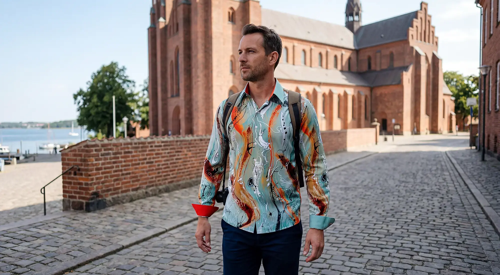 A tourist strolls through the Danish city of Roskilde. He is wearing the eye-catching RUDER shirt from GERMENS.