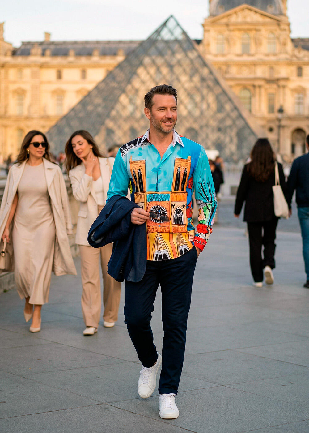 Ein Mann trägt das bunte Hemd SAVOIR VIVRE PARIS von GERMENS artfashion und läuft durch Paris.