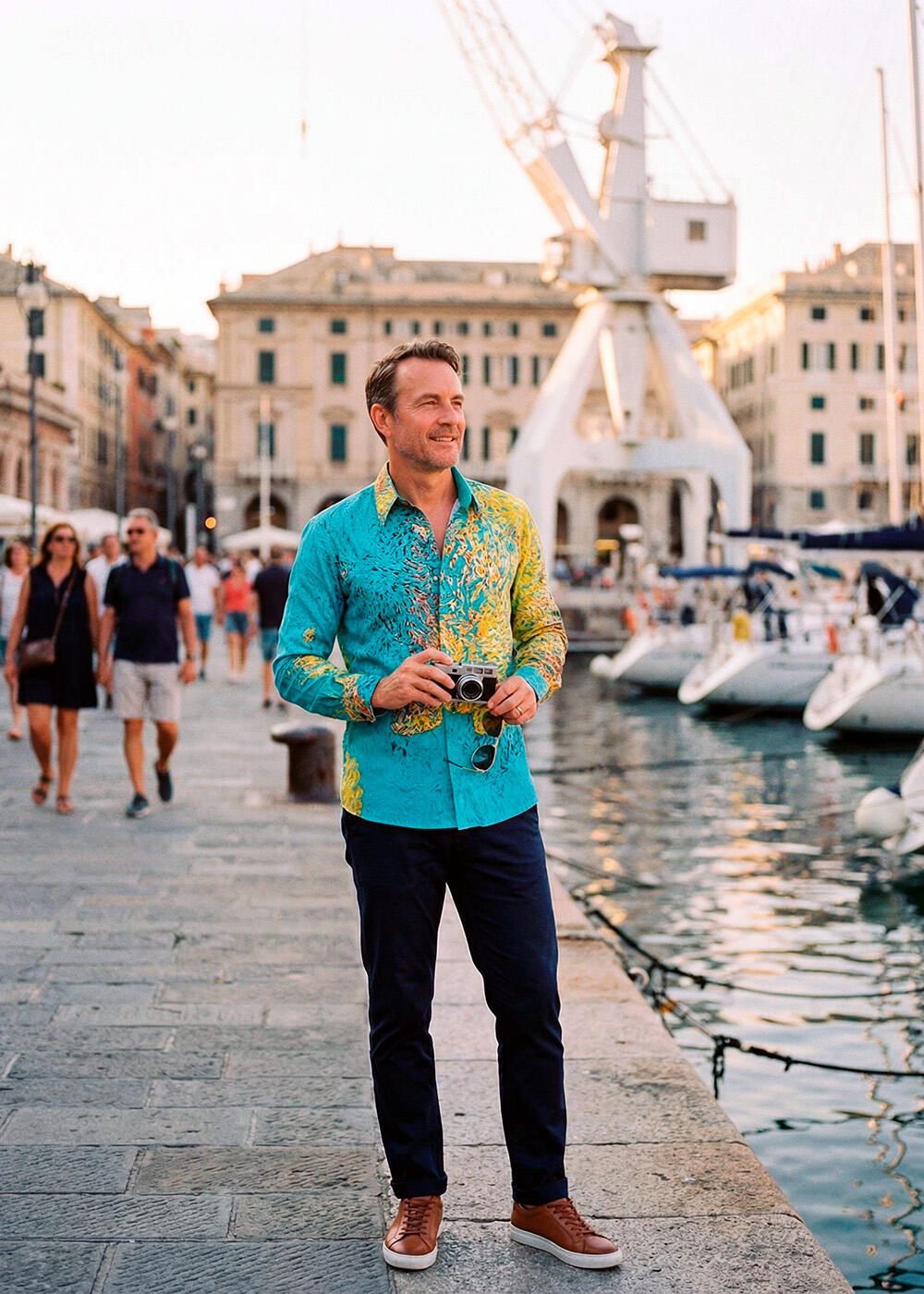 A man wears the yellow and turquoise FRAXI BERMULO shirt by GERMENS artfashion at the port of Genoa.