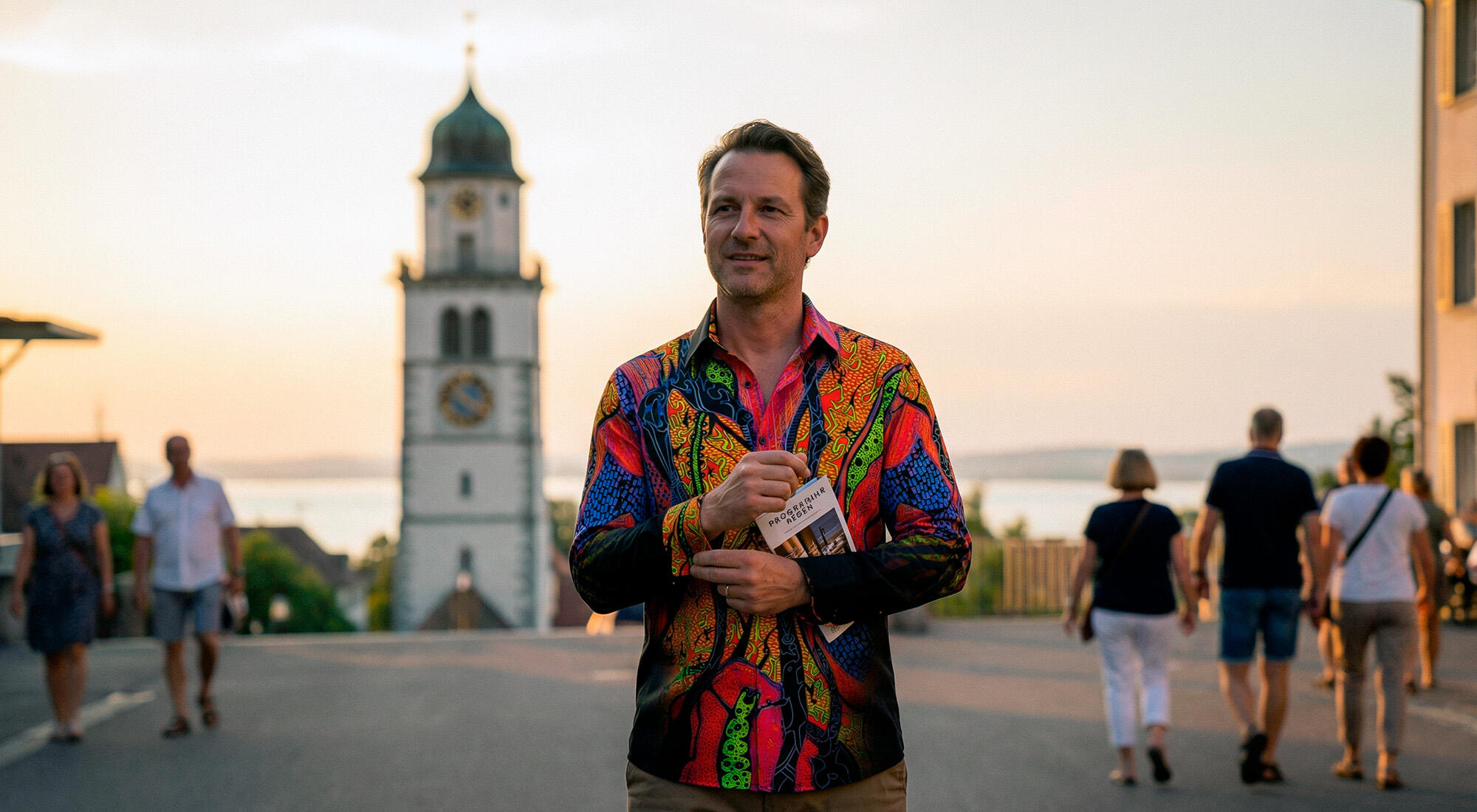 A man strolls through Bregrenz and attracts attention with his colorful AFRICAN DREAM shirt from GERMENS.