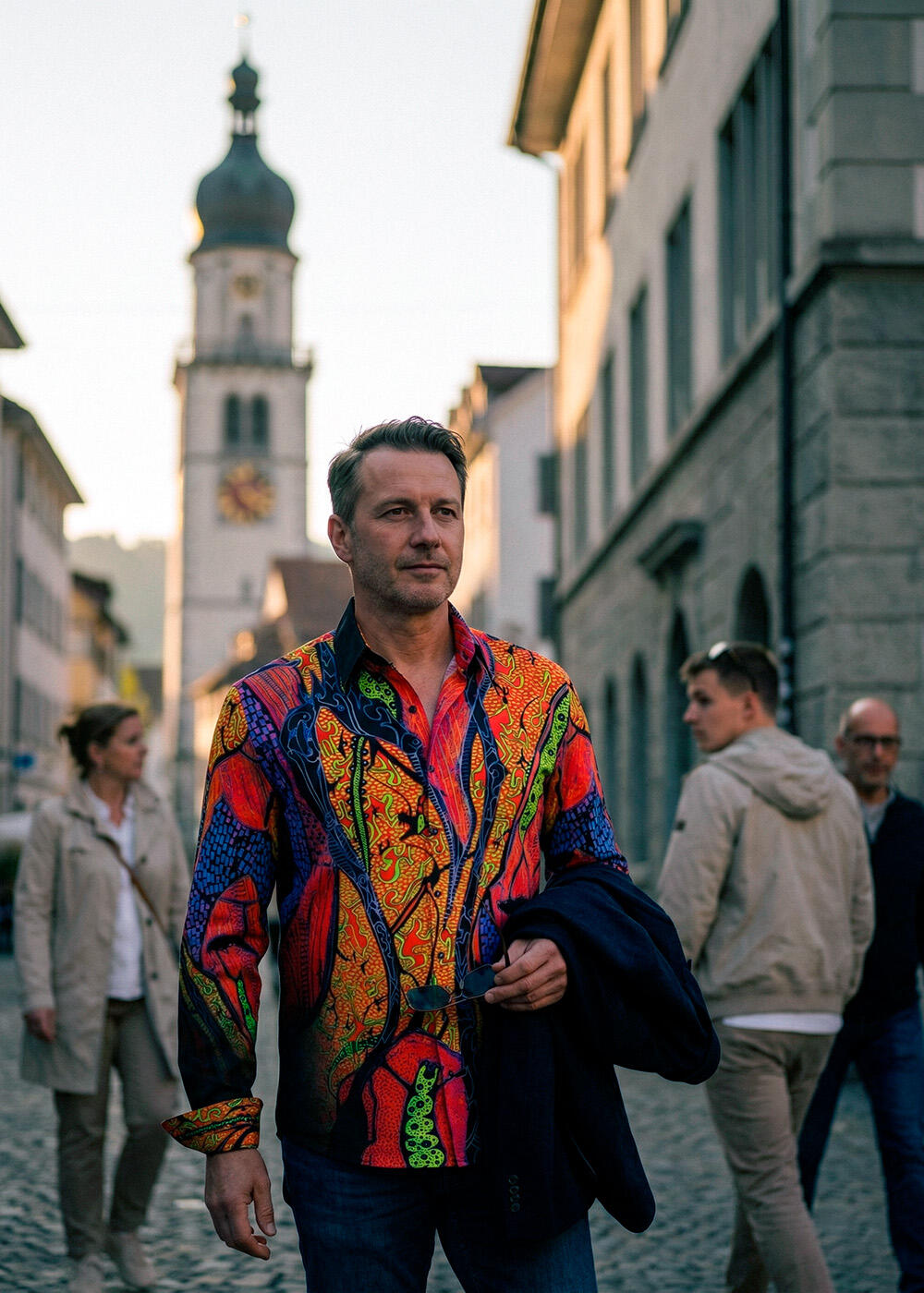 A man strolls through Bregrenz and attracts attention with his colorful AFRICAN DREAM shirt from GERMENS.