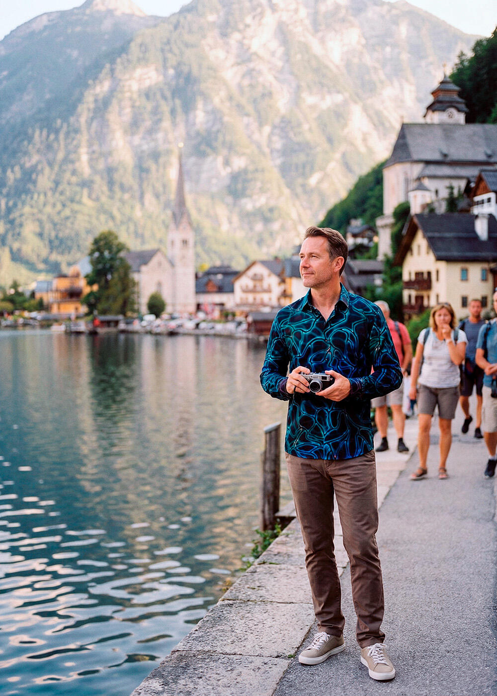 A tourist walks along the shore of Lake Hallstatt. He is wearing the black and blue NETWORK MIRAKEL shirt by GERMENS.