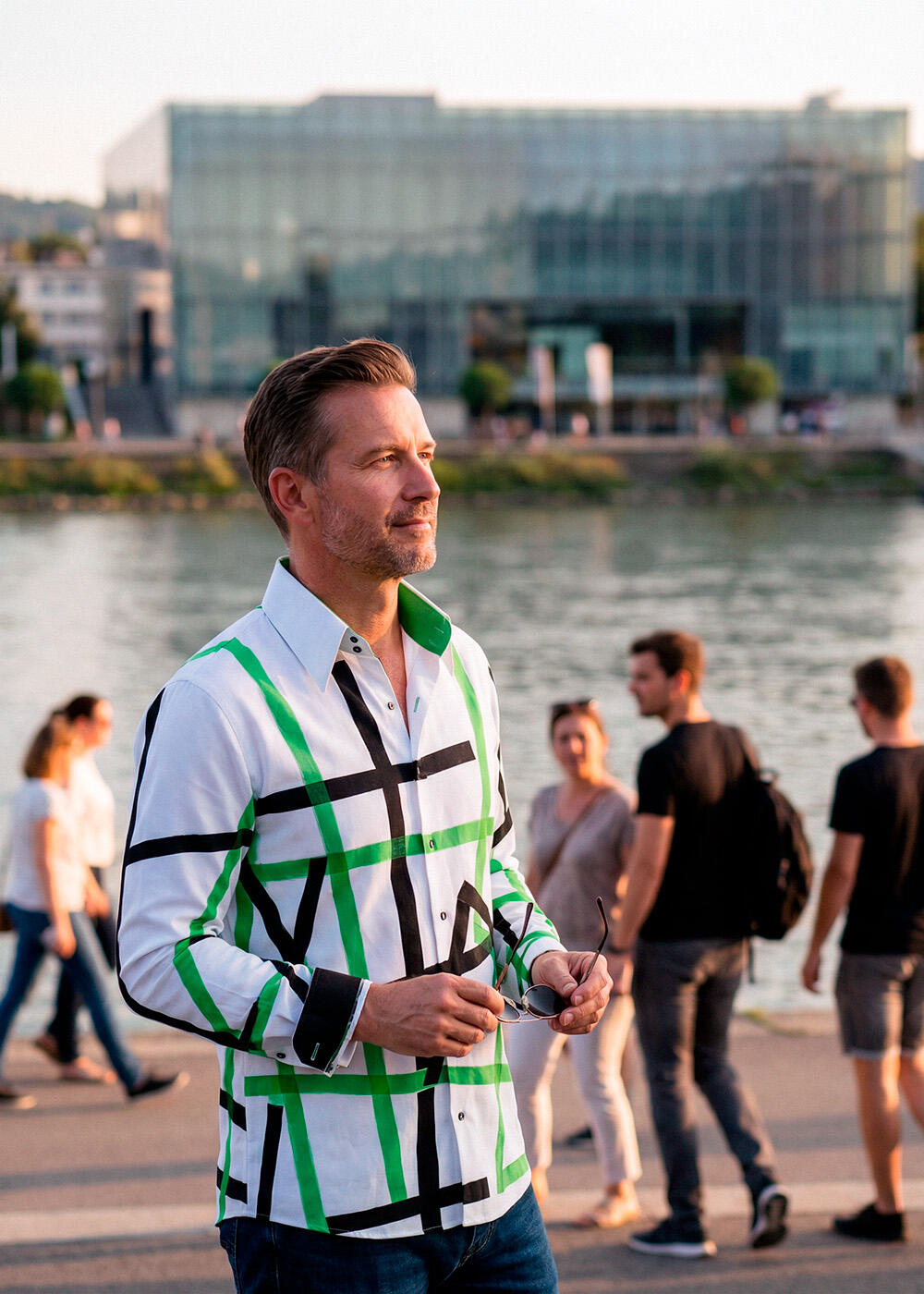 A man walks through the city of Linz wearing the white GERMENS TIOLI shirt.