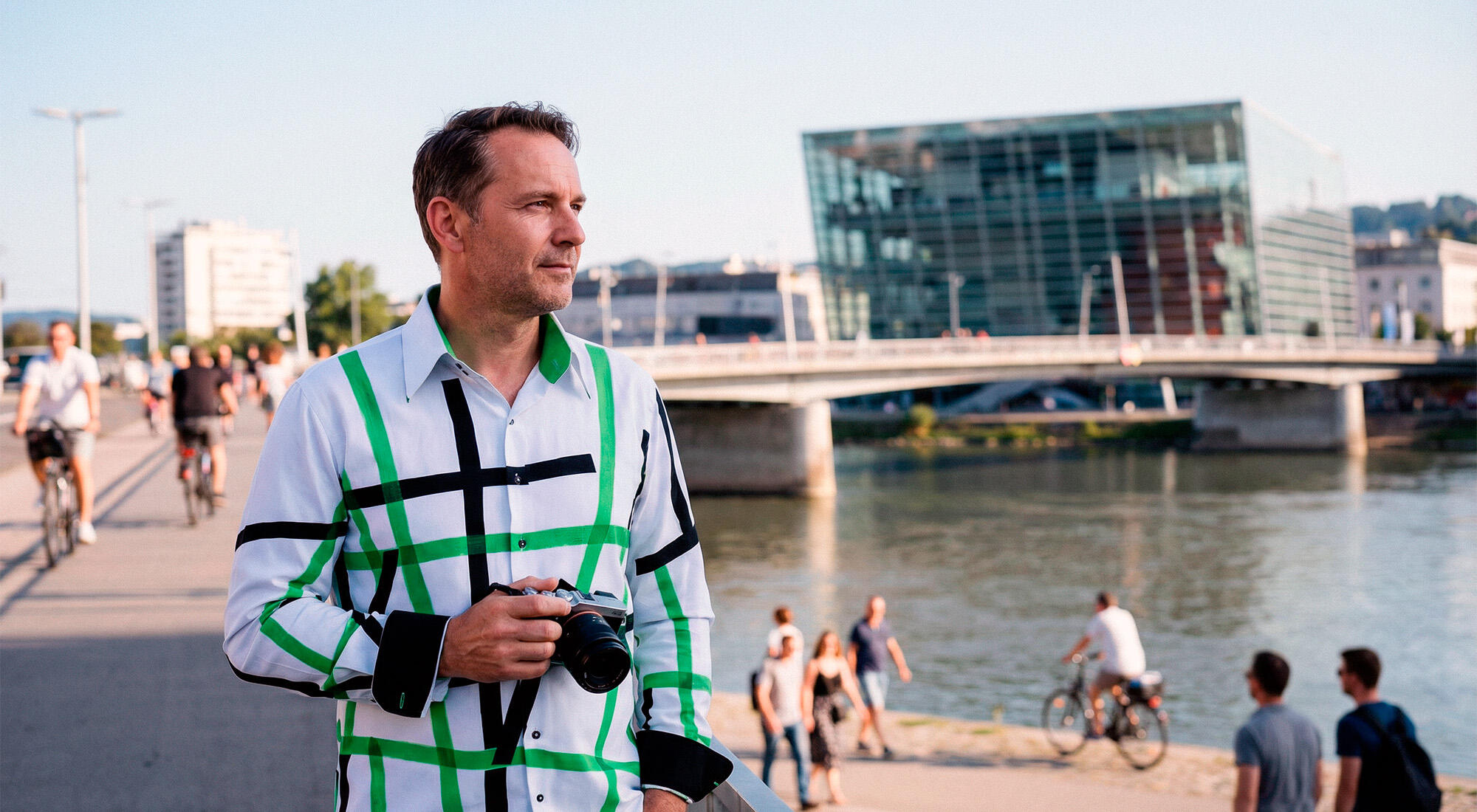 A man walks through the city of Linz wearing the white GERMENS TIOLI shirt.