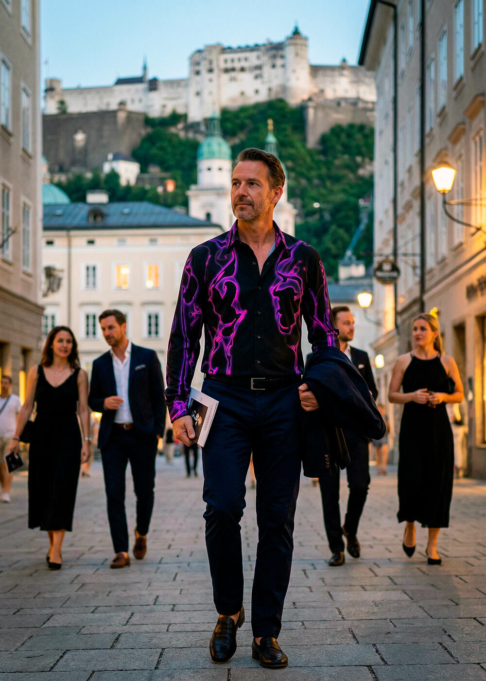A man walks through the city of Salzburg wearing the black and purple GERMENS ULTRA V shirt.
