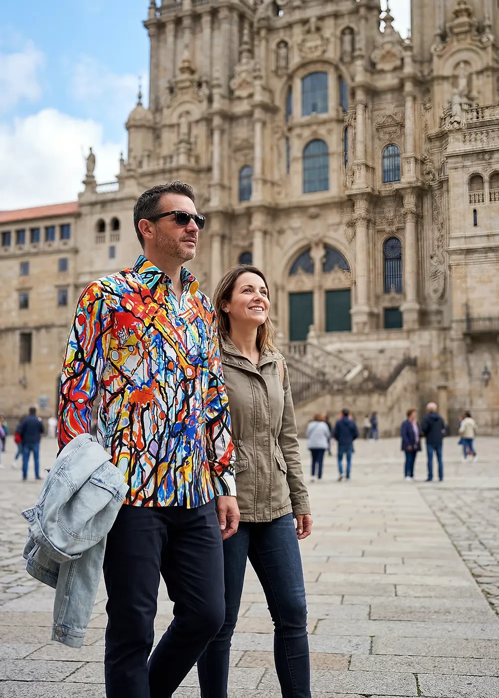A married couple is walking in the Spanish city of Santiago de Compostela. The man is wearing the colorful KNOCKOUT shirt by GERMENS.