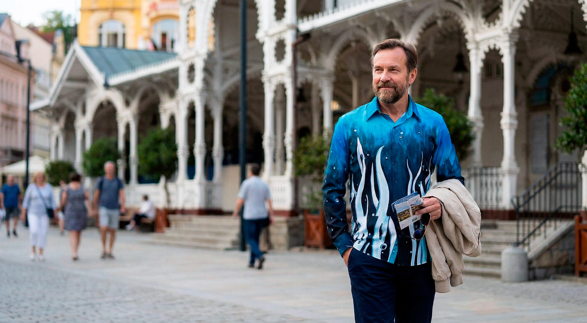 A man walks through the Czech spa town of Karlovy Vary wearing the blue GERMENS shirt SURREAL UNDERWATERWORLD.