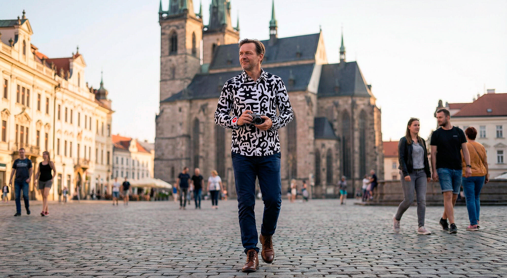 A man walks through the Czech city of Pilsen wearing the black and white GERMENS JUPPI shirt.